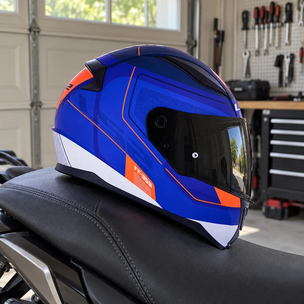 LS2 Rapid azul e laranja em cima do banco da moto, com ferramentas penduradas ao fundo